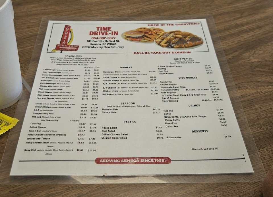 Menu board with burgers, fries, and chicken.